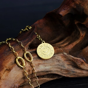 Minimalist gold sun flower smiley face pendant necklace on dark textured wood background