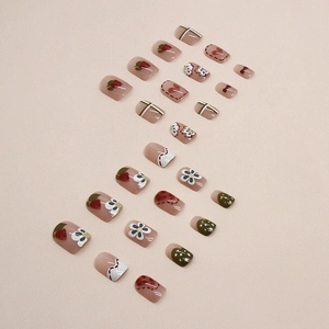 Short square press-on nails with red strawberry and white daisy patterns on pink base