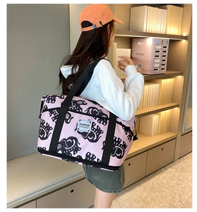 Detailed view of large pink elephant print duffle bag with heavy-duty shoulder straps
