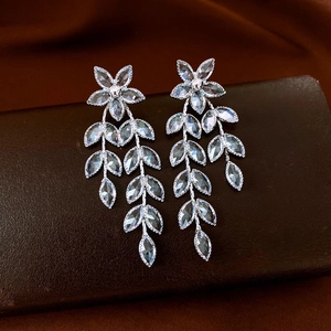 Detailed view of vintage silver earrings with floral zircon tassels on dark background