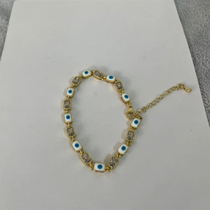 Detail view of 14K gold plated bracelet with square zircon and evil eye enamel charms