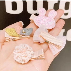 Detail of pink fabric-covered clips with bunny, lace flower, and glitter bow designs