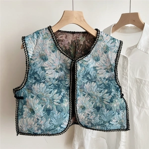 Detailed view of teal floral jacquard vest with black woven trim and V-neckline