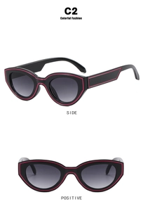 Détail de lunettes de soleil œil-de-chat avec montures noires et contours rouges vifs