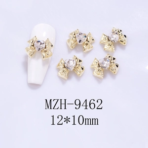Detailed view of 12x10mm gold bow nail charms with heart crystal rhinestones