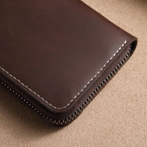 Brown matte leather card holder wallet with hand-stitched details and metal zipper
