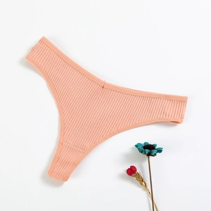 Flat lay of a salmon pink ribbed cotton thong with thin elastic straps on white background
