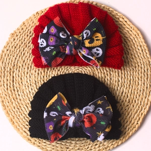 Detail of baby knit turban hats with Halloween pumpkin bow and soft vertical texture