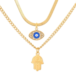 Double-layer gold necklace with Hamsa hand and blue Evil Eye pendant in a layered style