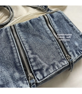 Nahaufnahme der gewaschenen Denim-Tasche mit Doppel-Metallreißverschlüssen und Textur