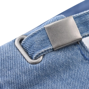 Macro view of blue washed denim texture and adjustable silver metal buckle on baseball cap