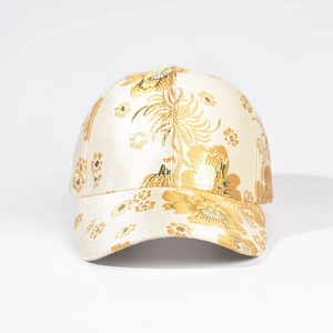 Detail of champagne gold floral embroidery and satin texture on the baseball cap