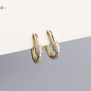 Macro shot of gold oval hoop earrings with sparkling pavé cubic zirconia detail