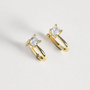 Elegant gold U-shaped earrings with a round zircon stone on a clean grey background