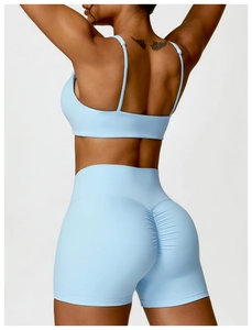 Détail de la brassière de sport bleu clair et du short froncé à taille haute