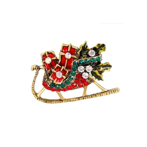 Detail of Christmas sleigh brooch with red enamel gifts and colorful rhinestones