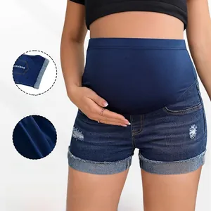 Dettaglio degli shorts premaman in denim con fascia elastica e strappi alla moda