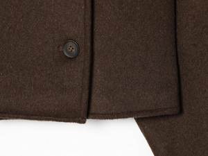 Macro detail of high-quality brown wool fabric texture and marble-patterned button