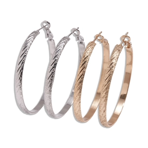 Textured metallic hoop earrings in gold and silver finish with diagonal stripe patterns