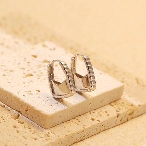 Macro detail of S925 sterling silver handbag earrings with woven texture on stone