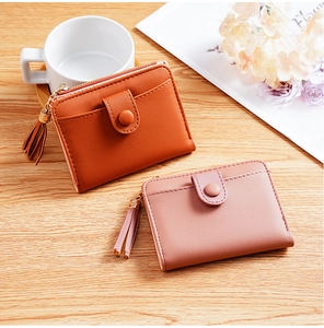 Detail of pink and orange PU leather wallets with snap buttons and elegant tassels