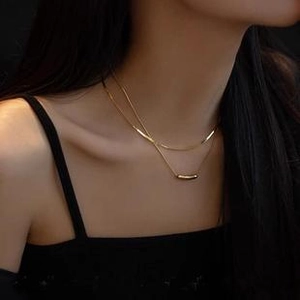 Close-up of double-layer gold snake bone chain necklace worn by a fashion model