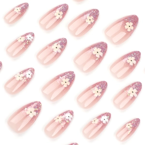 Pink gradient almond false nails with fine glitter tips and 3D white floral decorations