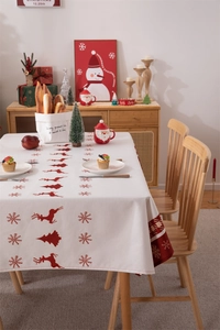 Detailed Christmas tablecloth with red reindeer and snowflake patterns on wood table