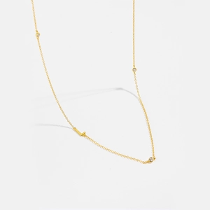 Detailed view of gold S925 silver necklace with sparkling zircons and letter L pendant