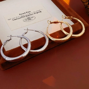 Detail view of gold and silver chunky hoop earrings on a velvet jewelry tray