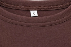 Close-up of the round neckline and fine stitching on a brown modal long sleeve T-shirt