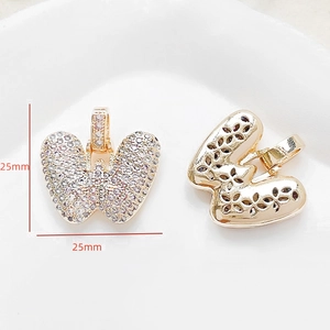 Detailed view of a 25mm gold butterfly pendant with cubic zirconia and floral hollow back