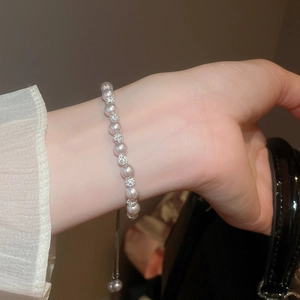 Gros plan d'un bracelet en perles violet clair avec des sphères serties de diamants