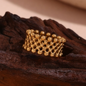 Detailed close-up of 18K gold plated mesh ring with beads on dark wood background
