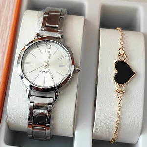 Dettaglio dell'orologio al quarzo argento e bracciale dorato con cuore in una scatola