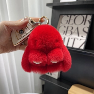 Close-up of a soft red plush bunny keychain with a fluffy texture for bags and car keys