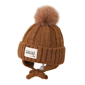 Brown kids knit earflap winter hat with thick pompom and decorative front patch