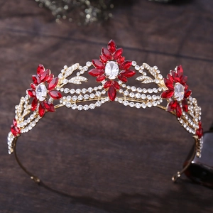 Close-up of golden bridal crown featuring large red crystal flowers and leaf details