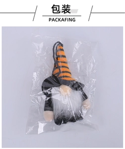 Close-up of a striped Halloween gnome plush ornament inside its transparent packaging