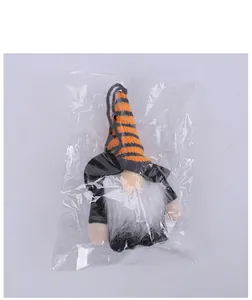 Close-up of a striped Halloween gnome plush ornament inside its transparent packaging