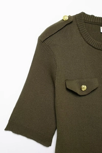 Detail of army green knitted dress featuring shoulder epaulettes and gold buttons