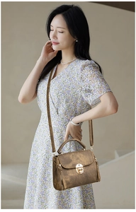 Detailed view of the vintage brown textured leather handbag with a gold metal lock buckle