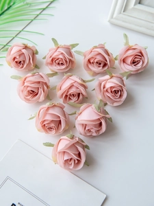 Detailed view of ten pink silk artificial rose heads arranged on a white background