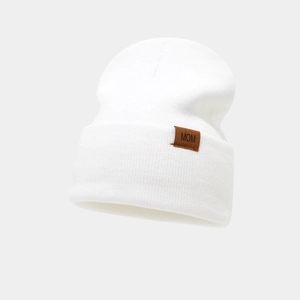 Close-up of white ribbed knit beanie with a brown leather patch featuring MOM text