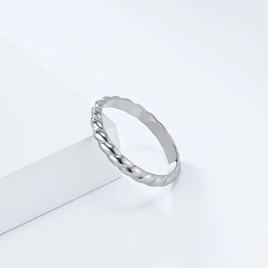 Macro detail of silver twisted rope ring on a minimalist white display block