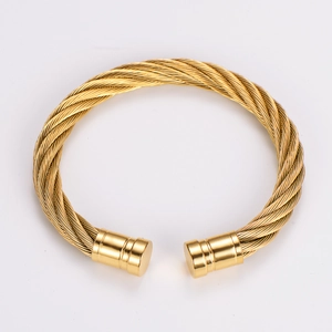 Detail of gold twisted wire cable bracelet showing intricate weave and cylindrical ends