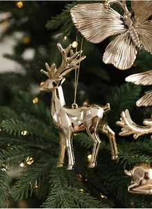 Addobbi dorati geometrici a forma di renna e farfalla appesi all'albero di Natale