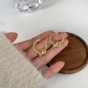Gold-plated knot-twisted C-shape earrings with intricate woven texture for women