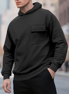 Detail of black hooded sweatshirt featuring a functional cargo chest pocket with flap