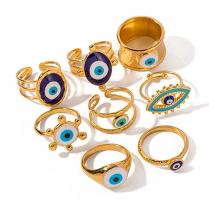 Set of 9 vintage evil eye gold rings with colorful enamel designs on white background